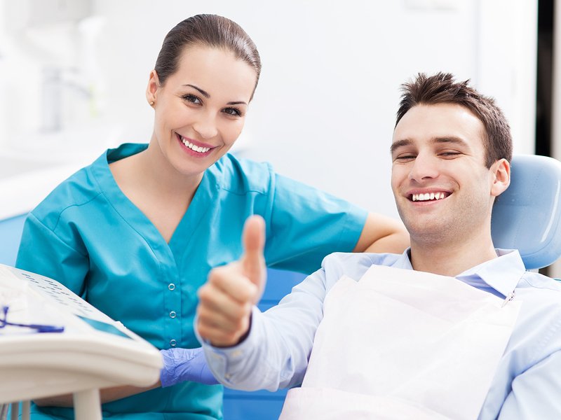 man giving thumbs up at dentist office